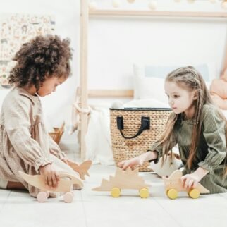 Surrounded by their toys. They can move freely while playing in their eco-friendly dress from Ecokiddoz; the fabric is breathable and soft. They giggle while arranging their toy figurines, giving each one a unique backstory.